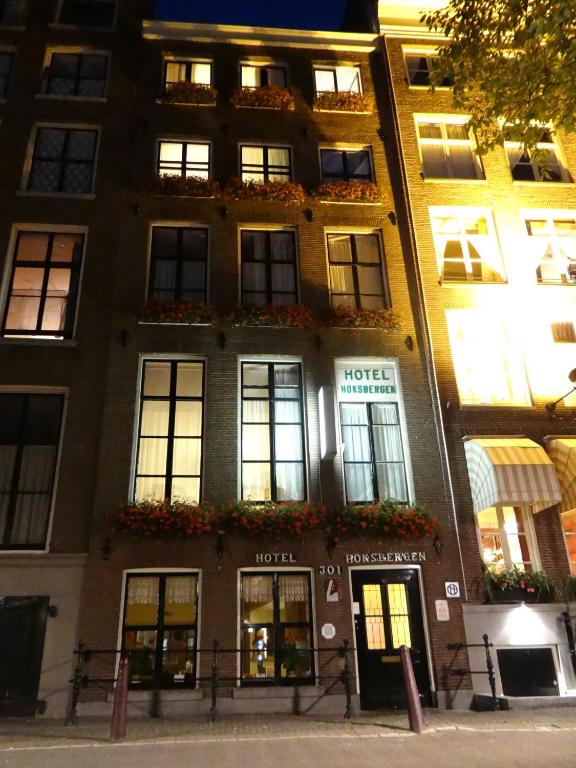 ein Gebäude mit Fenstern und Blumen davor in der Unterkunft Hotel Hoksbergen in Amsterdam