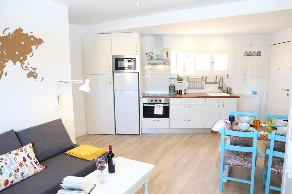 a living room with a couch and a kitchen at APARTAMENTO GRANADA CENTRO in Granada