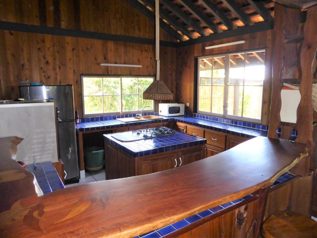 une cuisine avec des placards en bois et un comptoir en bois dans l'établissement Comfortable Maison, à Papetoai