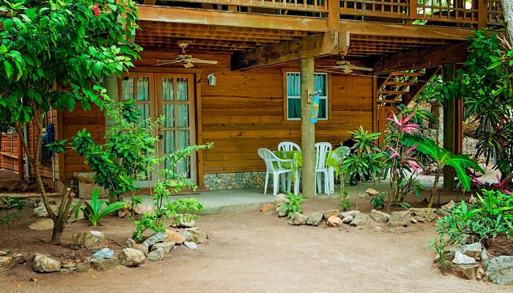 een huis met twee stoelen en een tafel ervoor bij Blue Island Divers Casa Descanso in Sandy Bay