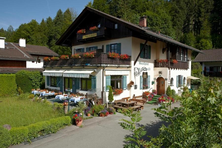 a large white house with tables and chairs in front of it at Gasthaus am Zierwald in Grainau