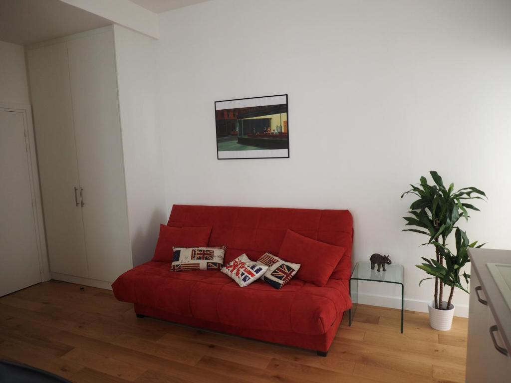 a red couch sitting in a living room at Appartement place Golbéry in Strasbourg