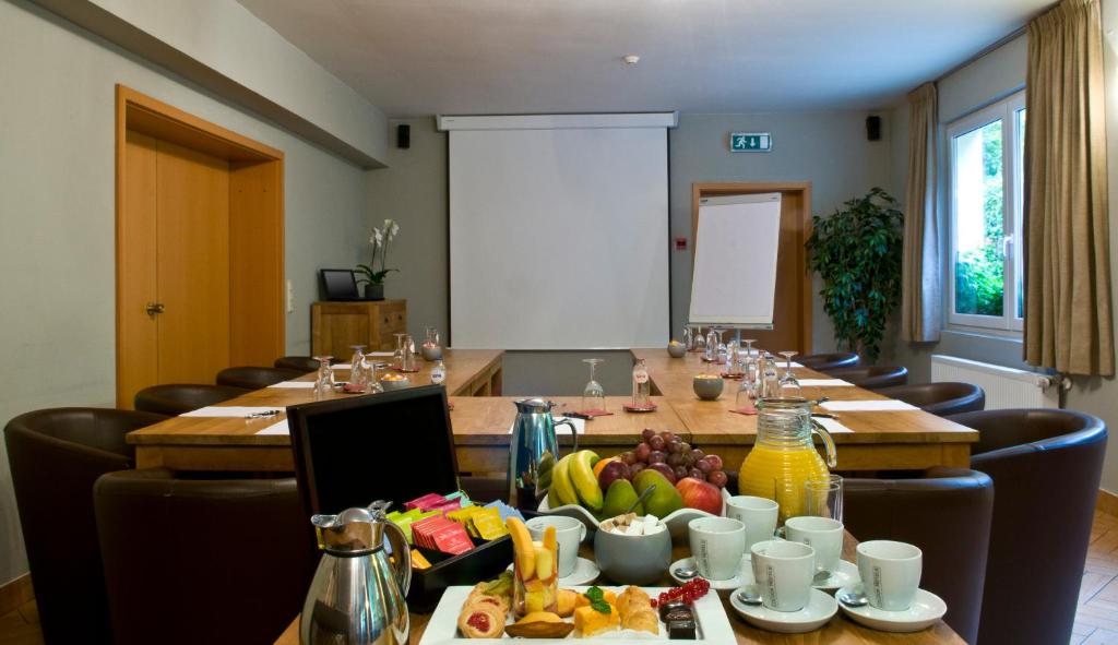 a conference room with a long table with food on it at Cocoon Hotel Belair in Bourscheid