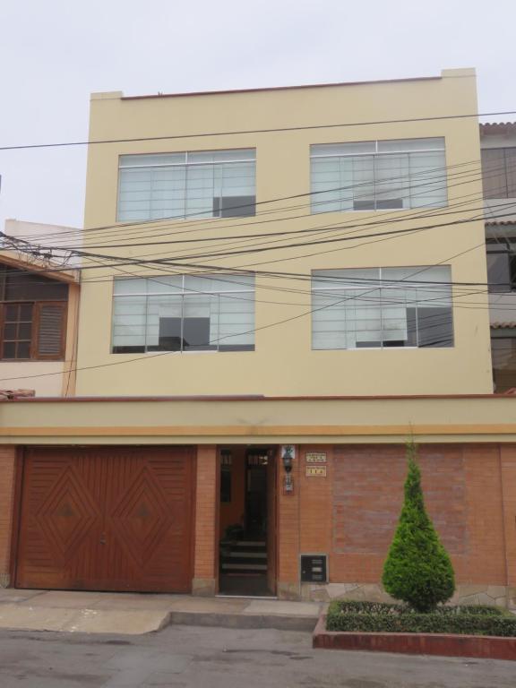 an apartment building with a garage and a building at Casa particular de Jorge Edinson in Lima