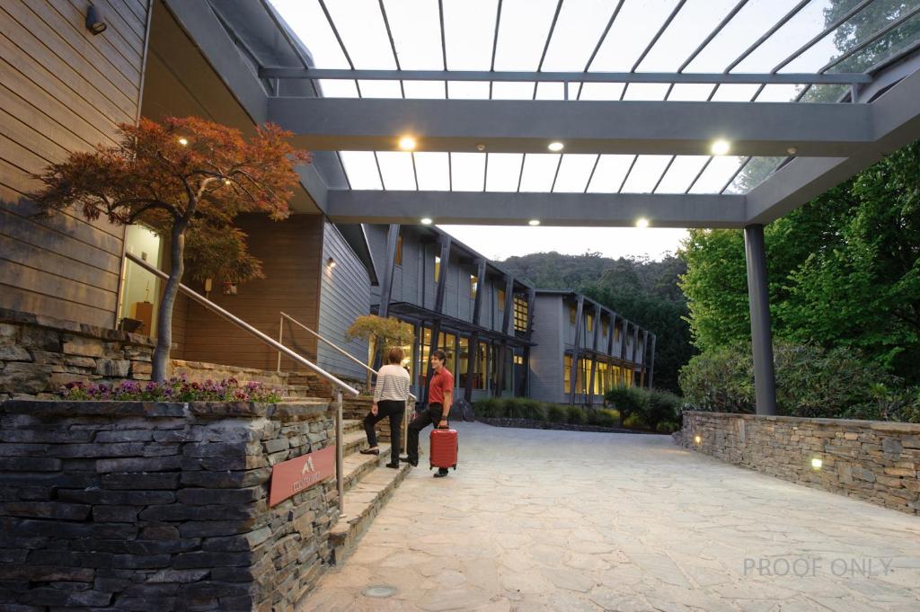 two people walking outside of a building with luggage at Panorama Retreat & Resort in Kalorama
