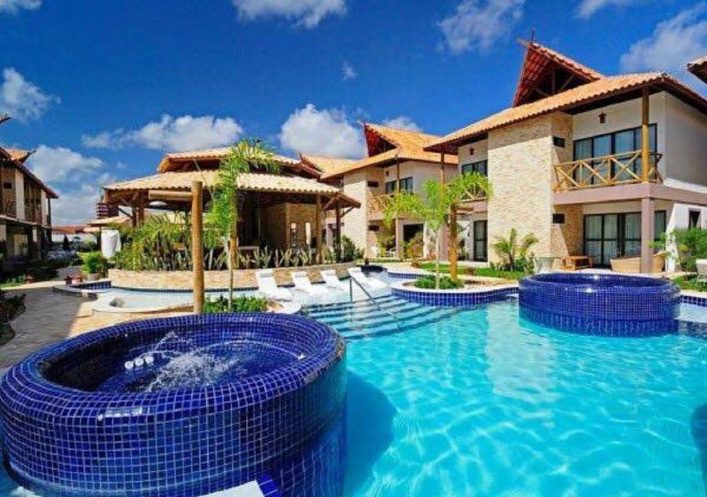 a swimming pool in front of a house at Bangalô com área de lazer estilo resort in Cabedelo