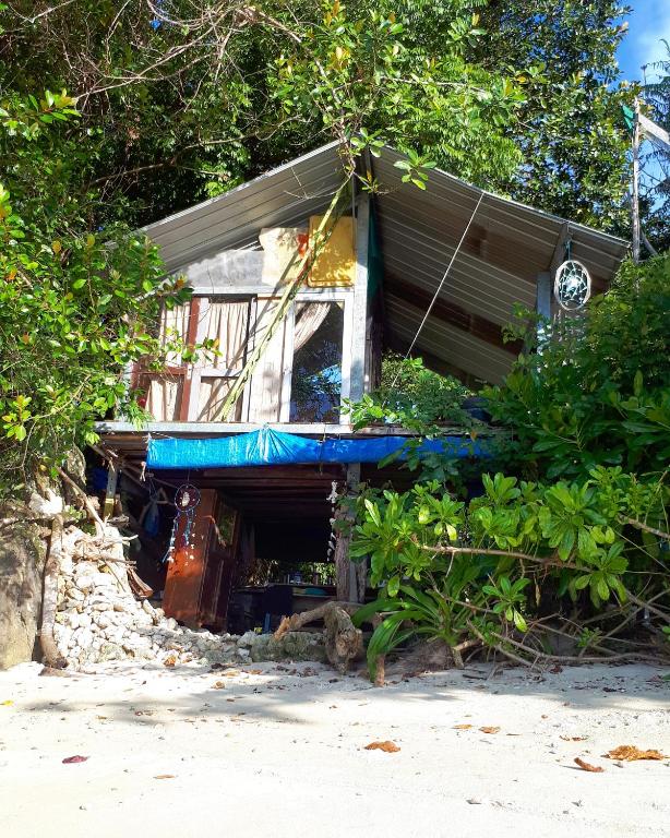 a house on the beach with a blue roof at Sumatra Ecolodge in Sungaipisang