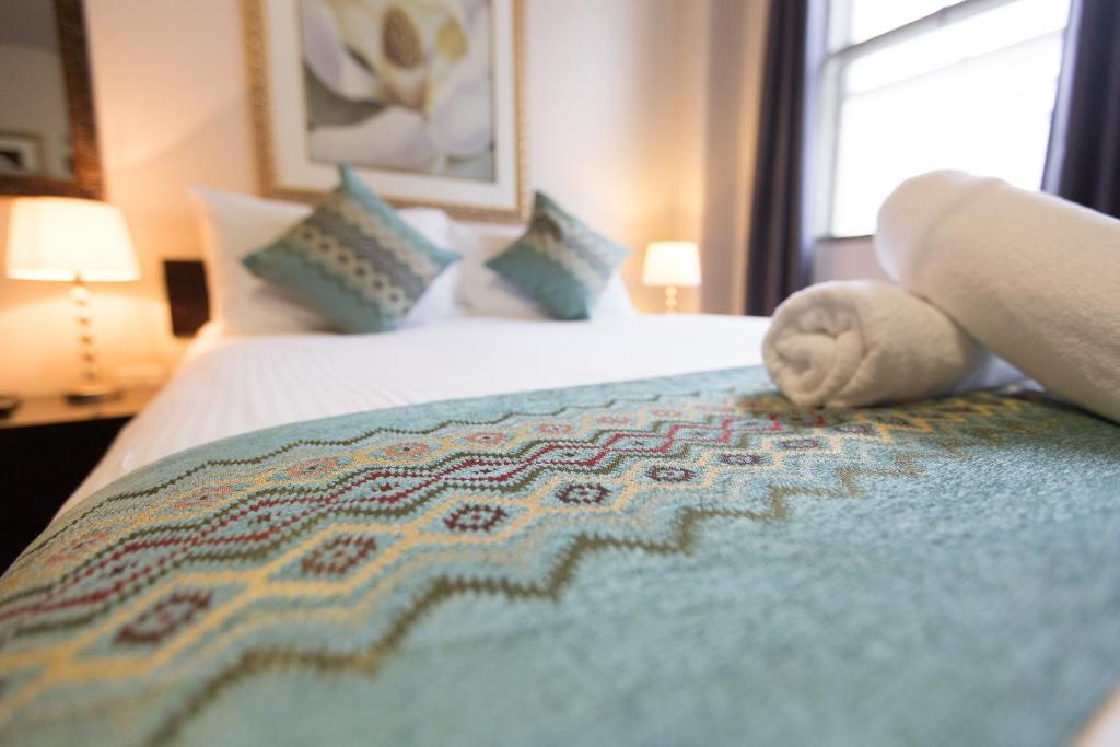 a hotel room with a bed with a blanket on it at City Square Motel in Melbourne