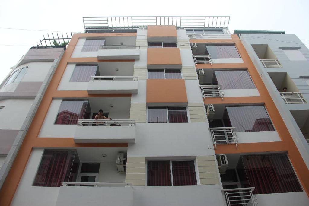 a man sits on a balcony of a building at Sai Gon River Hotel in Ho Chi Minh City