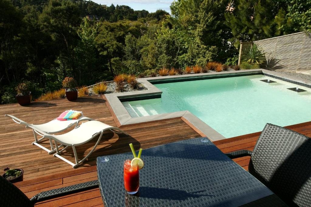 a swimming pool on a deck with a table and chairs at Decks of Paihia in Paihia