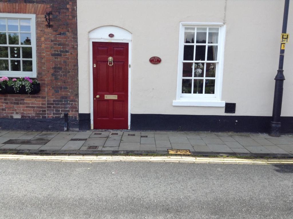 a red door on the side of a building at The Coach House in Bewdley