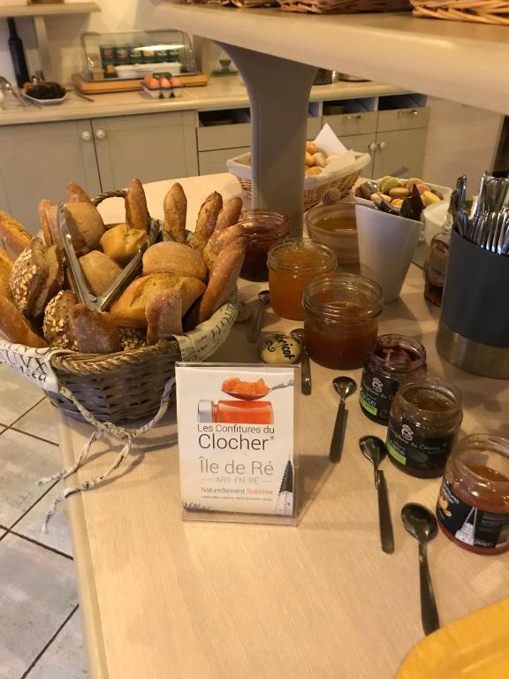 a table with a basket of bread and other food at Hôtel Le Peu Breton in Sainte-Marie-de-Ré