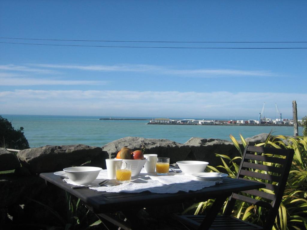 Pleasant View Bed & Breakfast في تيمارو: طاولة طعام وإطلالة على المحيط