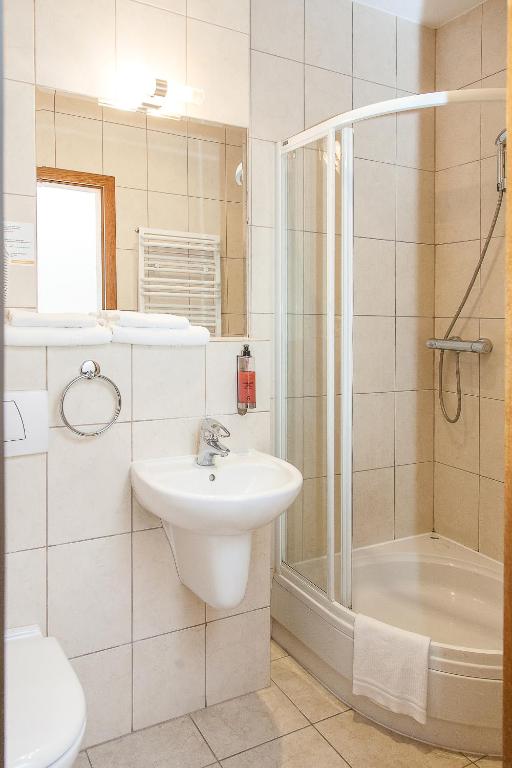 ein weißes Badezimmer mit Waschbecken und Dusche in der Unterkunft Willa Biala Lilia Old Town in Danzig