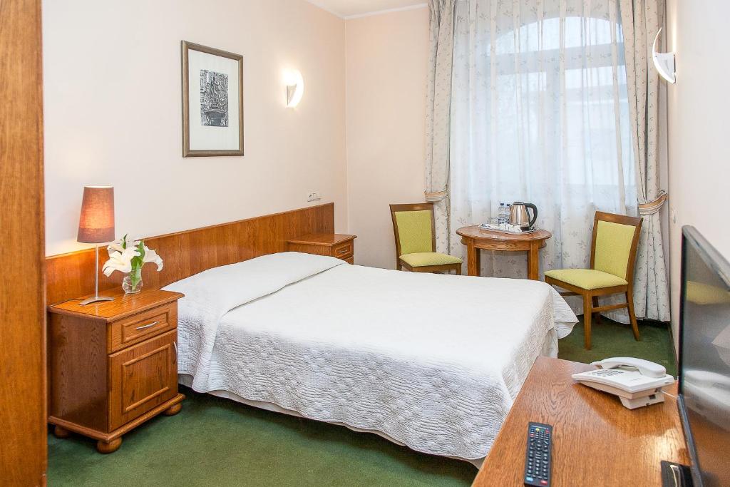 ein Hotelzimmer mit einem Bett und einem Schreibtisch in der Unterkunft Willa Biala Lilia Old Town in Danzig