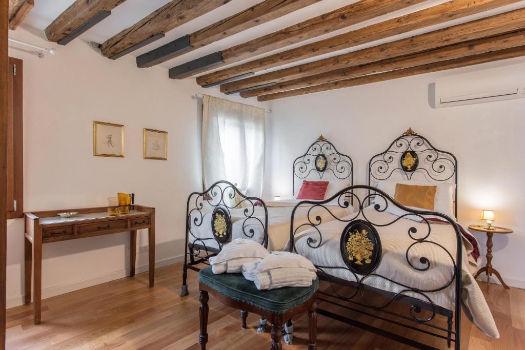 een slaapkamer met een bed, een bureau en een raam bij Appartamento Calle Furlani in Venetië