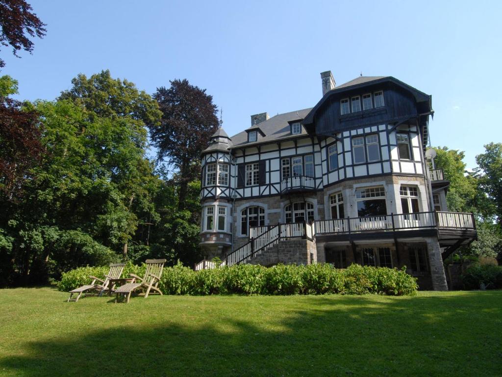 una casa grande con césped delante en Beautiful castle house in Spa with spacious garden, en Spa