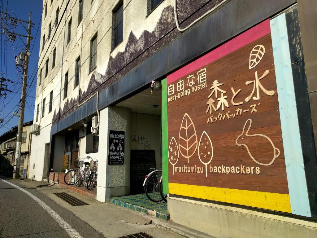 a building with a sign on the side of it at Moritomizu Backpackers in Nagano