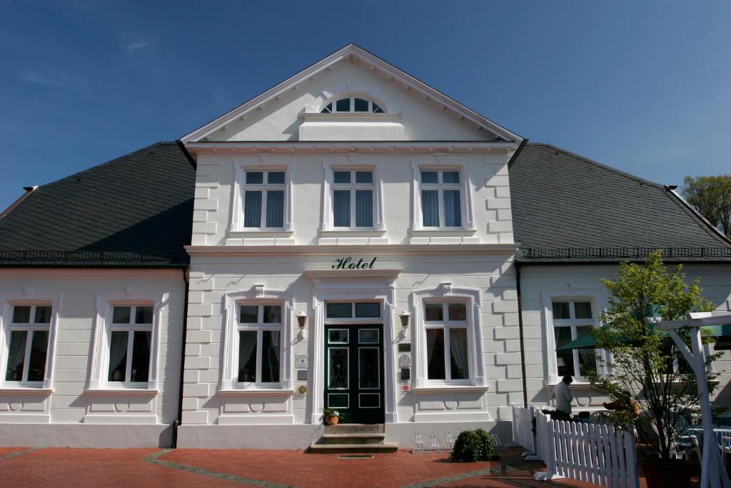 a white building with a black roof at Ringhotel Residenz Wittmund in Wittmund