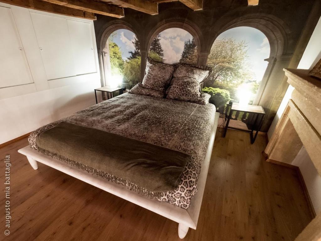 Casa Archi - Balcone sul Fiume في فيرونا: غرفة نوم بسرير كبير في غرفة ذات سقف