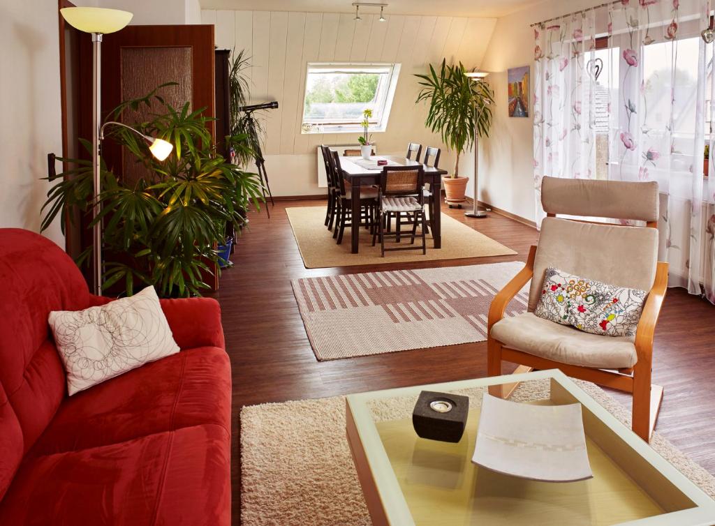 a living room with a red couch and a table at fewo-wachtendonk in Wachtendonk