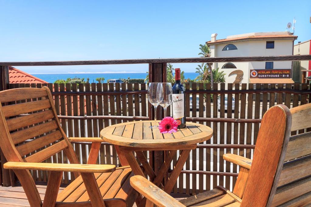 una mesa de madera con una copa de vino y 2 sillas en 3 Pepper Street by African Perfection, en Jeffreys Bay