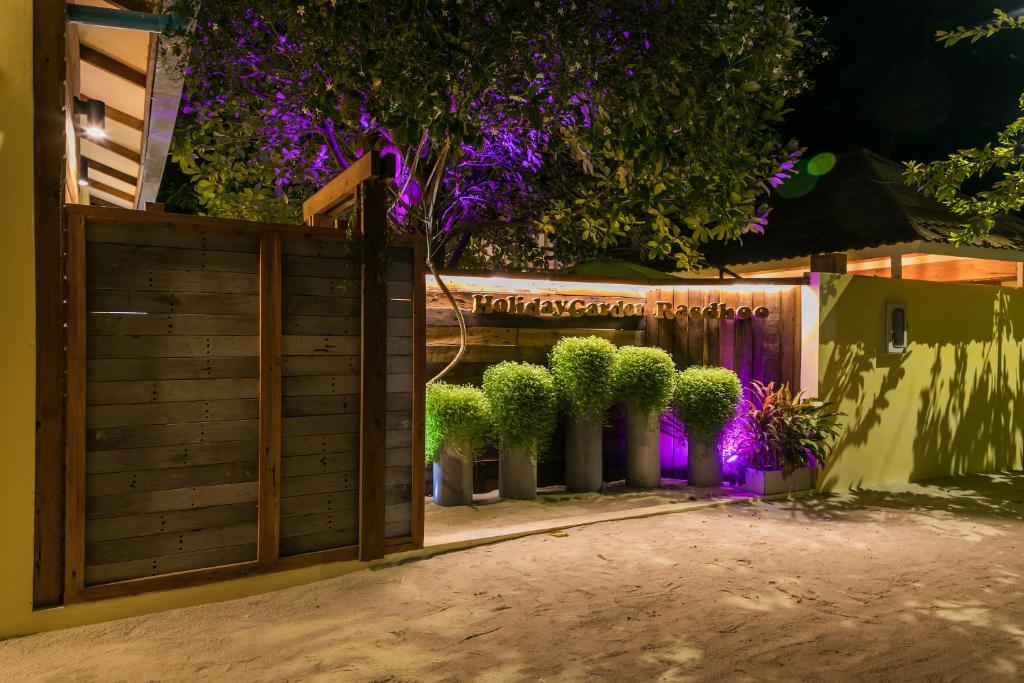 a driveway with a wooden gate and potted plants at Holiday Garden Rasdhoo in Rasdhoo