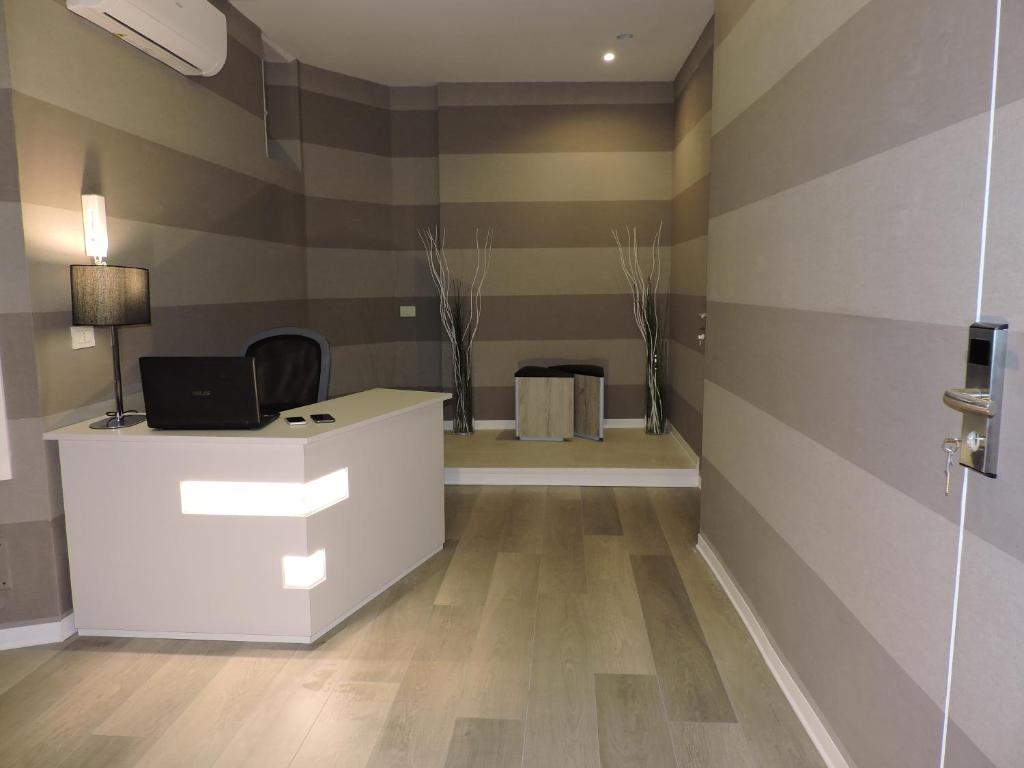 un ufficio con una scrivania bianca e un muro a righe di san cosimato suite a Roma