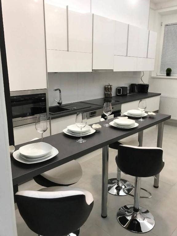 a kitchen with a table with plates and wine glasses at Manyi Apartman in Debrecen