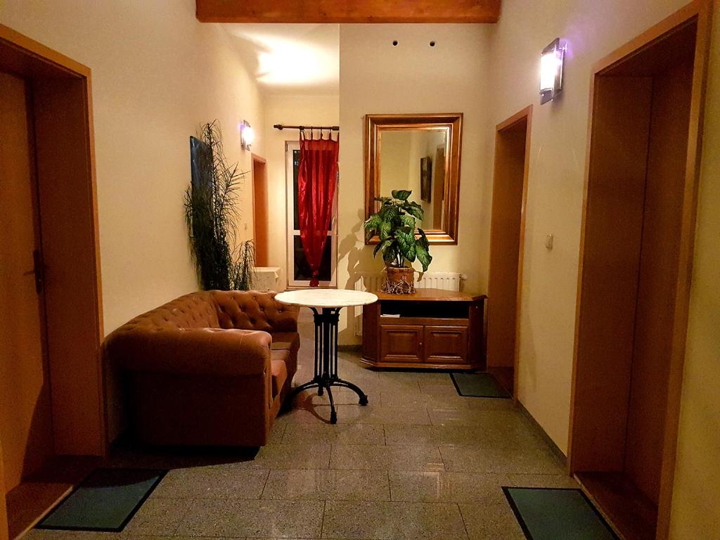 uma sala de estar com um sofá e uma mesa em Pension Balkan em Eisenhüttenstadt