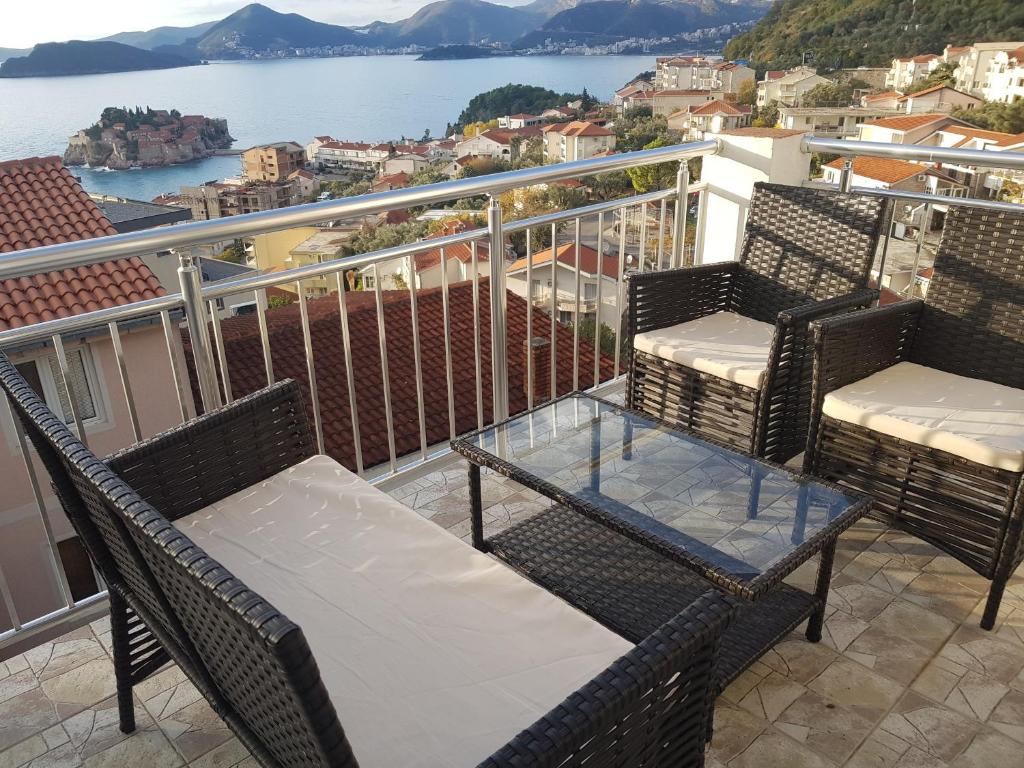 a balcony with two chairs and a glass table at Apartments Vukovic in Sveti Stefan