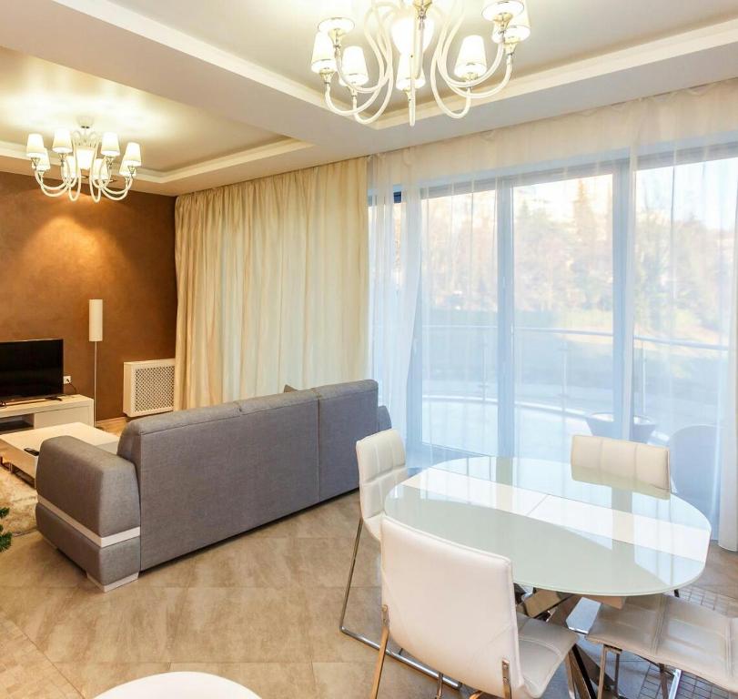 sala de estar con mesa de cristal y sofá en Апартаменты в Королевском парке, en Sochi