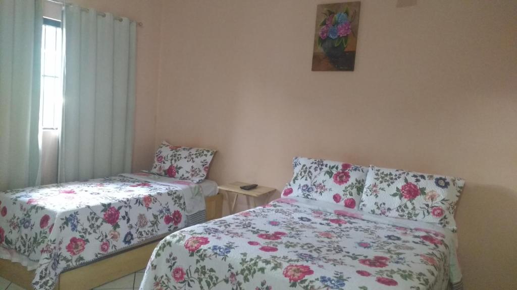 a bedroom with two beds and a window and a picture on the wall at Home Sweet Home Flats in Brasilia
