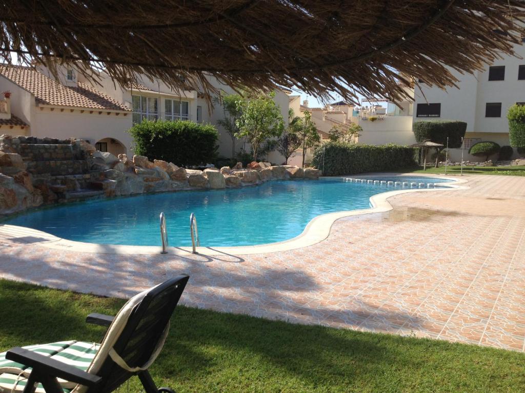 a chair sitting next to a swimming pool at Casa Lovia in Orihuela Costa