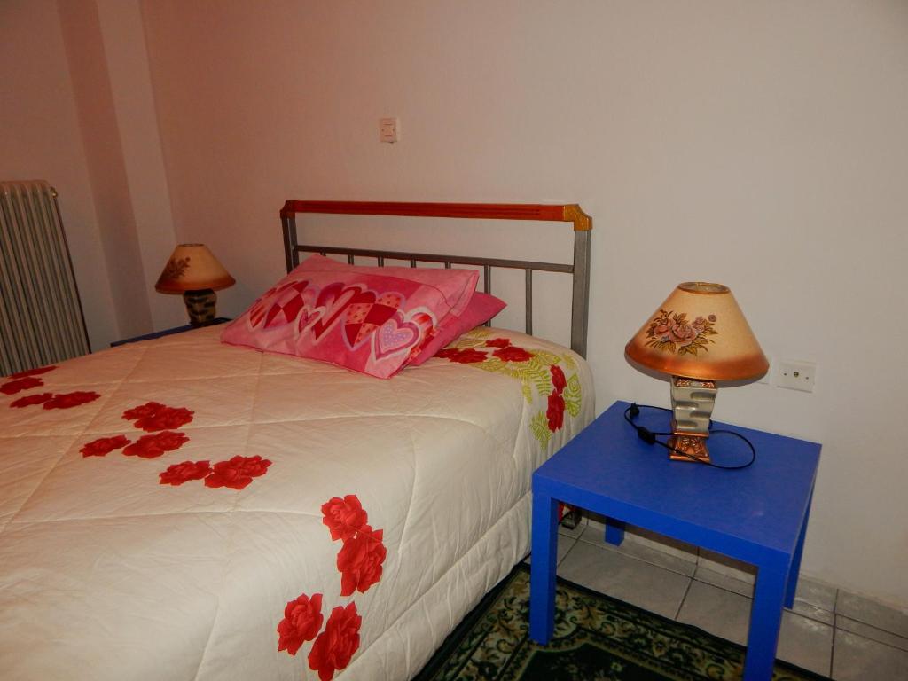 um quarto com uma cama com almofadas cor-de-rosa e uma mesa azul em Τripoli-Αpartments-Rooms-Stay em Trípoli