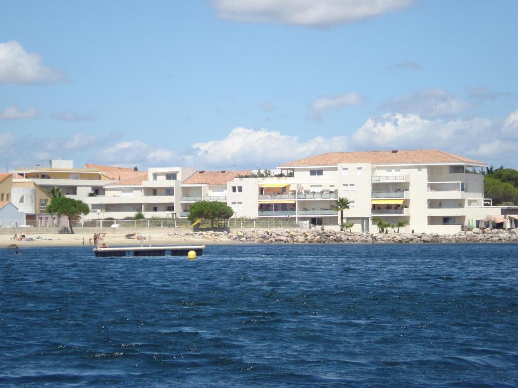 a building on the beach with a boat in the water at Port Mezua in Mèze