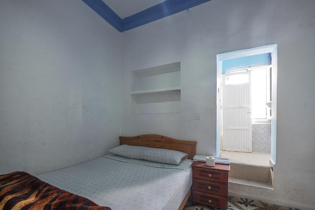 a bedroom with a bed and a window at Hostal La Joya in Chefchaouene