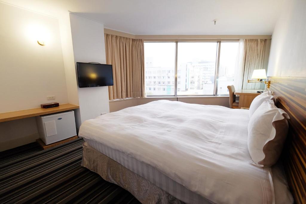 Una cama o camas en una habitaci&oacute;n de Dynasty Hotel