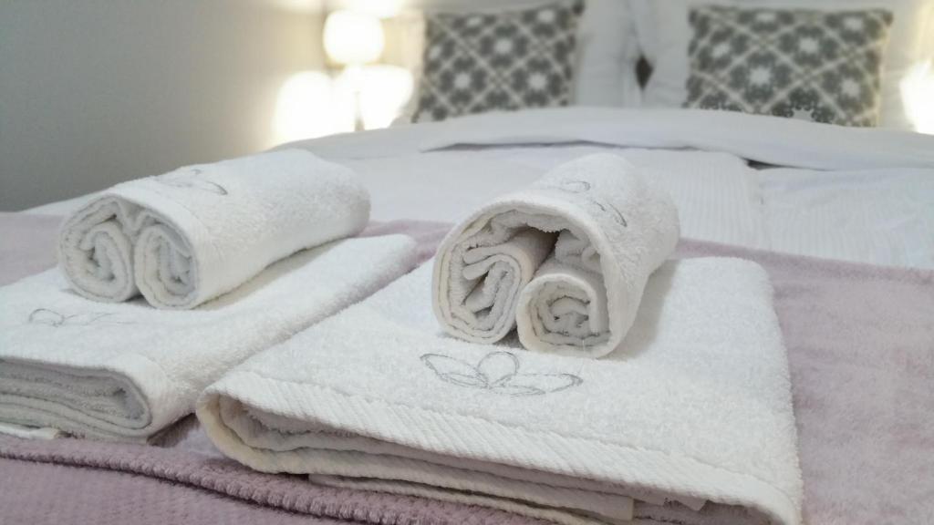 a pile of towels sitting on top of a bed at Royals Flower Apartments in Krakow