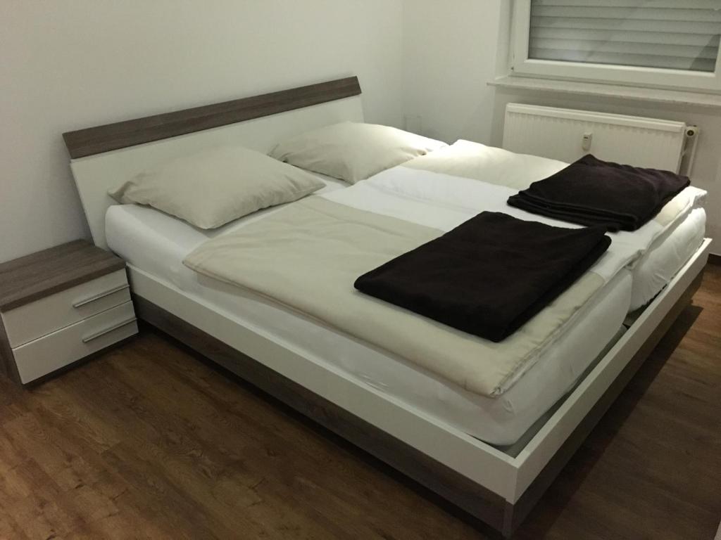 uma grande cama branca com um cobertor preto em Hotel Friesenhof em Westoverledingen