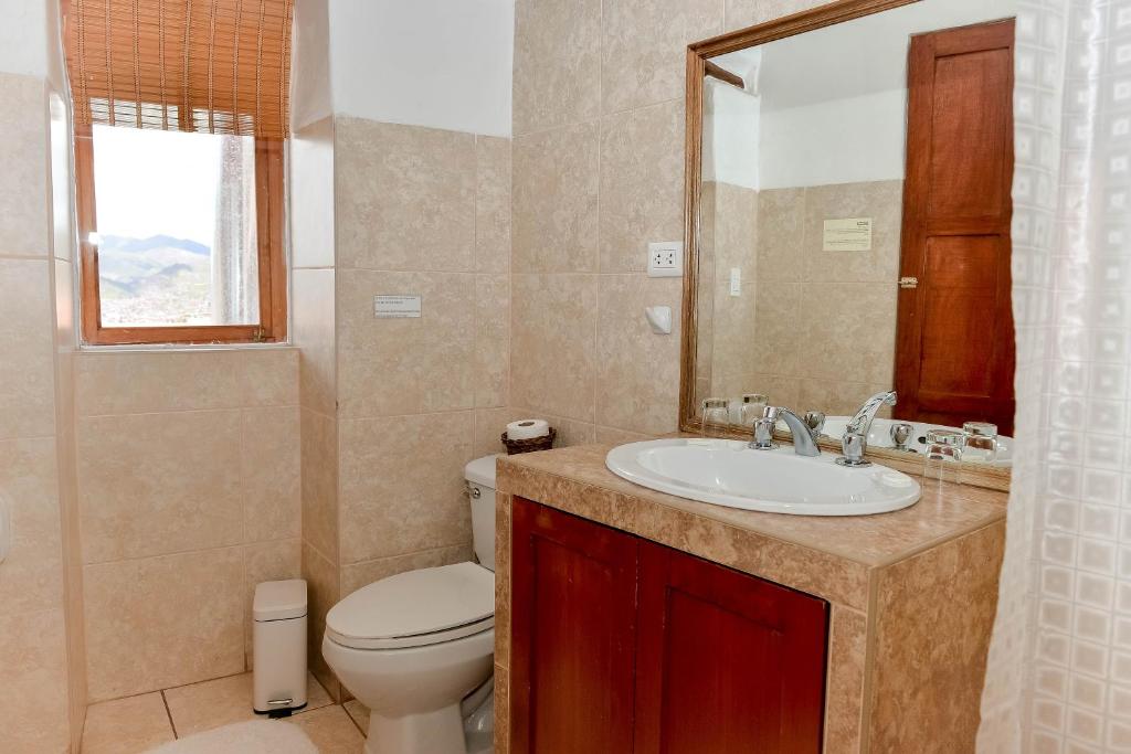 a bathroom with a toilet, sink and tub at El Balcón in Cusco