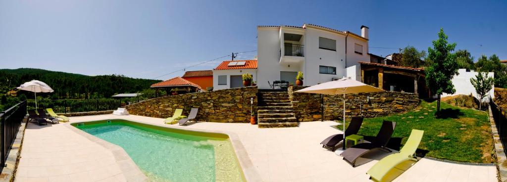 uma casa com piscina na frente de uma casa em Casa da Ladeira, Turismo Rural em Estreito