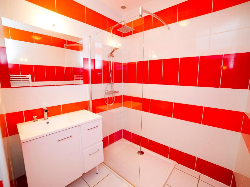 a red and white bathroom with a sink and shower at Le Crochet de Pervenche in Recoules-Prévinquières