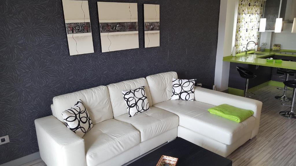 una sala de estar con un sofá blanco con almohadas. en Palm-Mar 2 rooms Lovely!!! en Arona