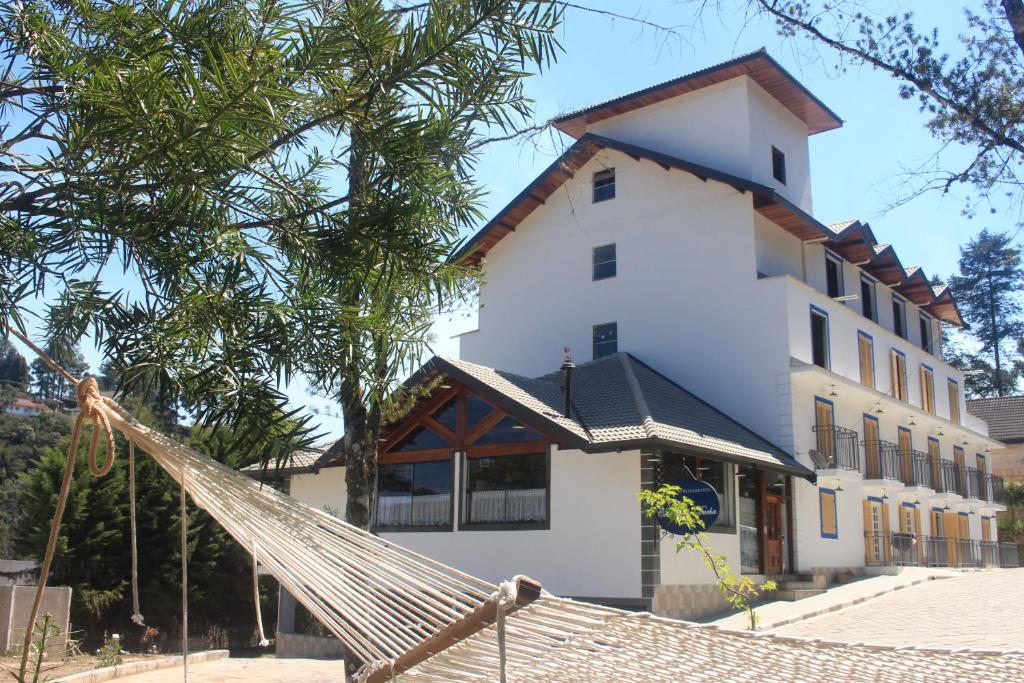 a building with a hammock in front of it at Casarão da Ducha Hotel in Campos do Jordão