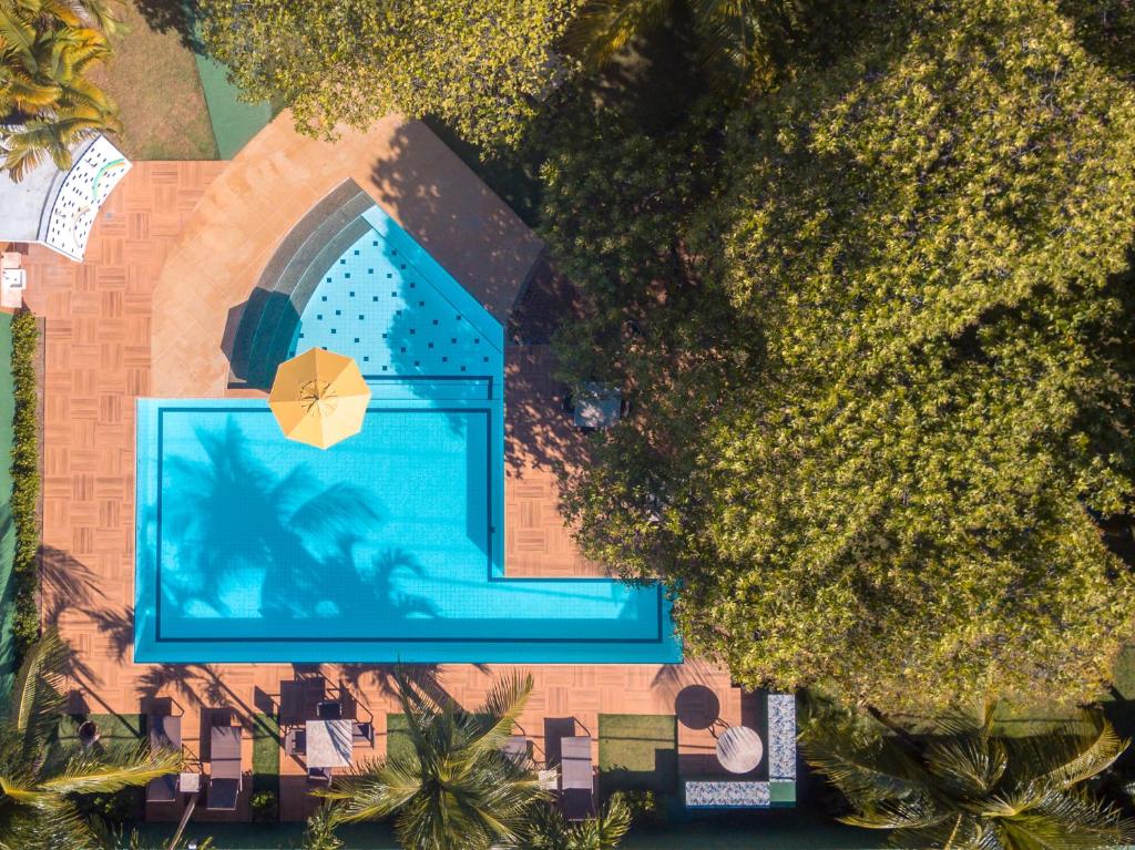 einen Blick über einen Pool mit Sonnenschirm in der Unterkunft Pousada Villa Maeva Itacimirim in Itacimirim