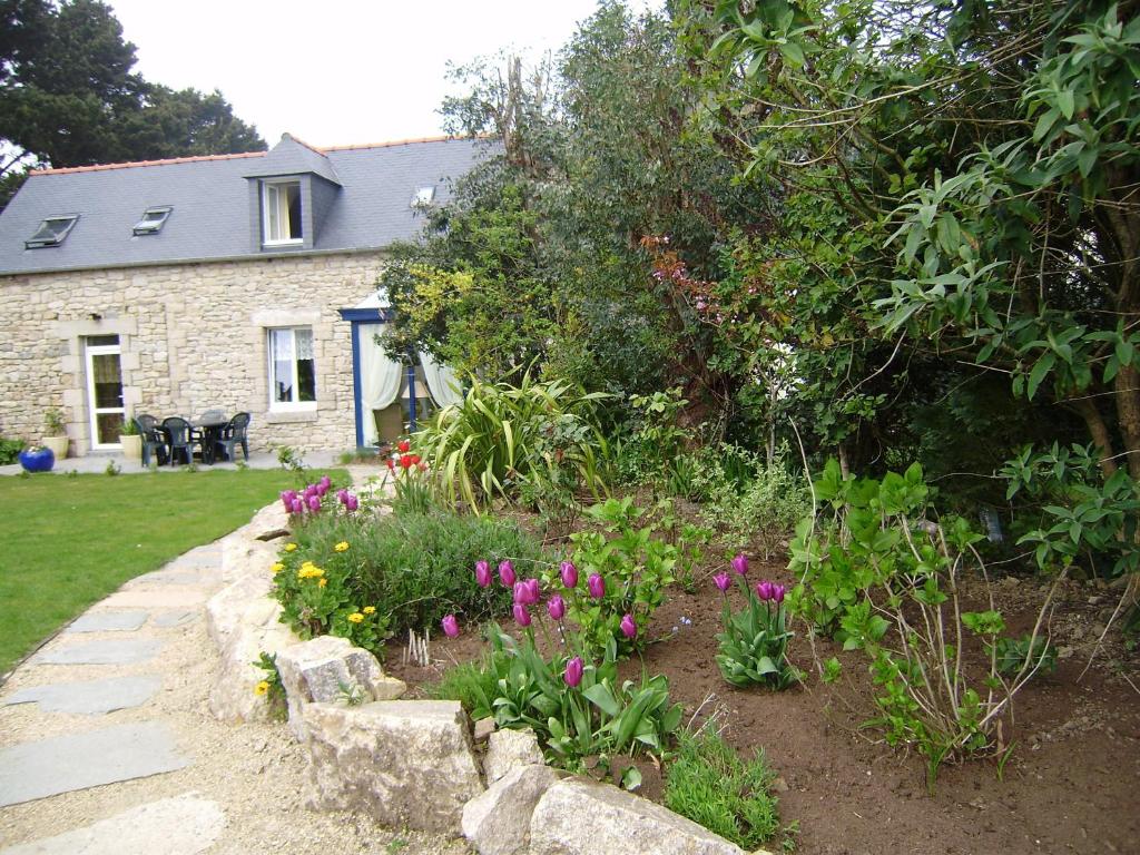 a garden in front of a stone house with flowers at Chambres d&#39;hôtes Air Marin in Lannion