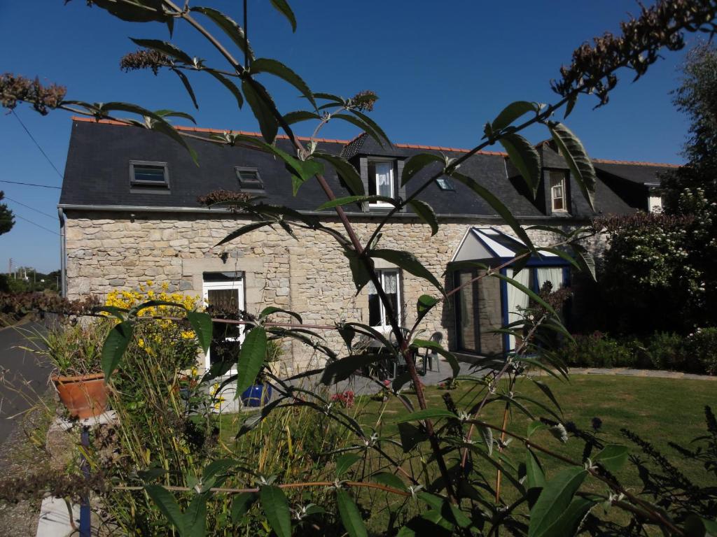 una antigua casa de piedra con un jardín delante de ella en Chambres d'hôtes Air Marin, en Lannion