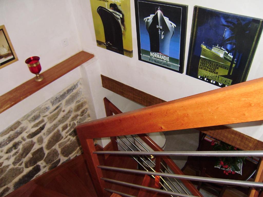 a staircase with posters on the wall and a wine rack at Chambres d&#39;hôtes Air Marin in Lannion