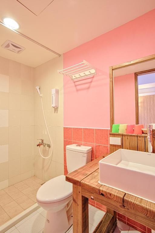 a bathroom with a white toilet and a sink at Love Summer Hostel in Hengchun South Gate